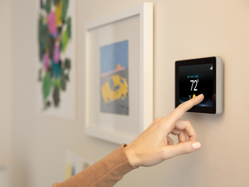 homeowner adjusting smart thermostat